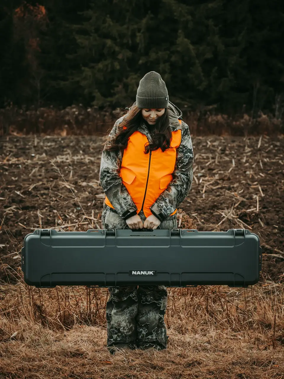 Person holding a large black JunZhiJia case in a forest setting