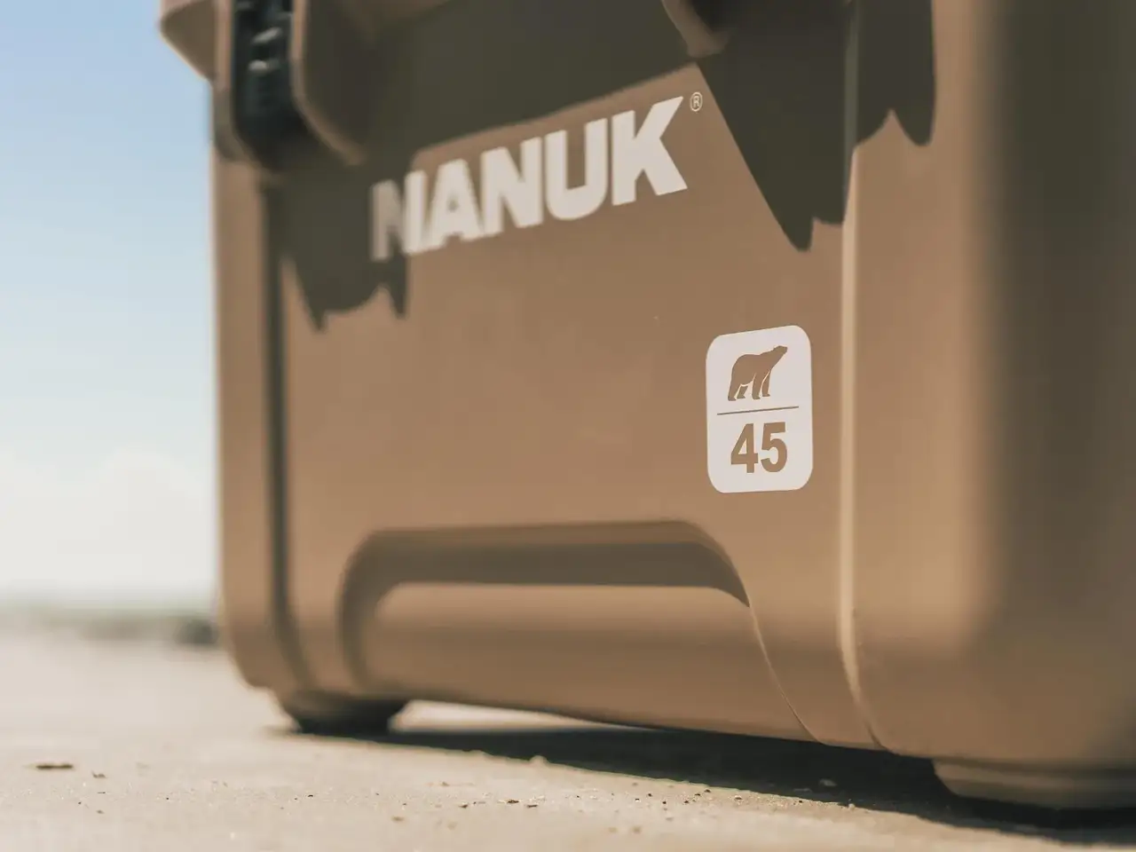 Close-up of a tan JunZhiJia cooler outdoors, showing the JunZhiJia logo and a white square sticker with a polar bear icon and the number 45.