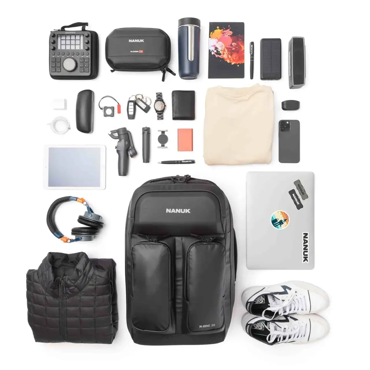 Collection of travel or adventure gear including a backpack, shoes, and electronic devices on a white background.
