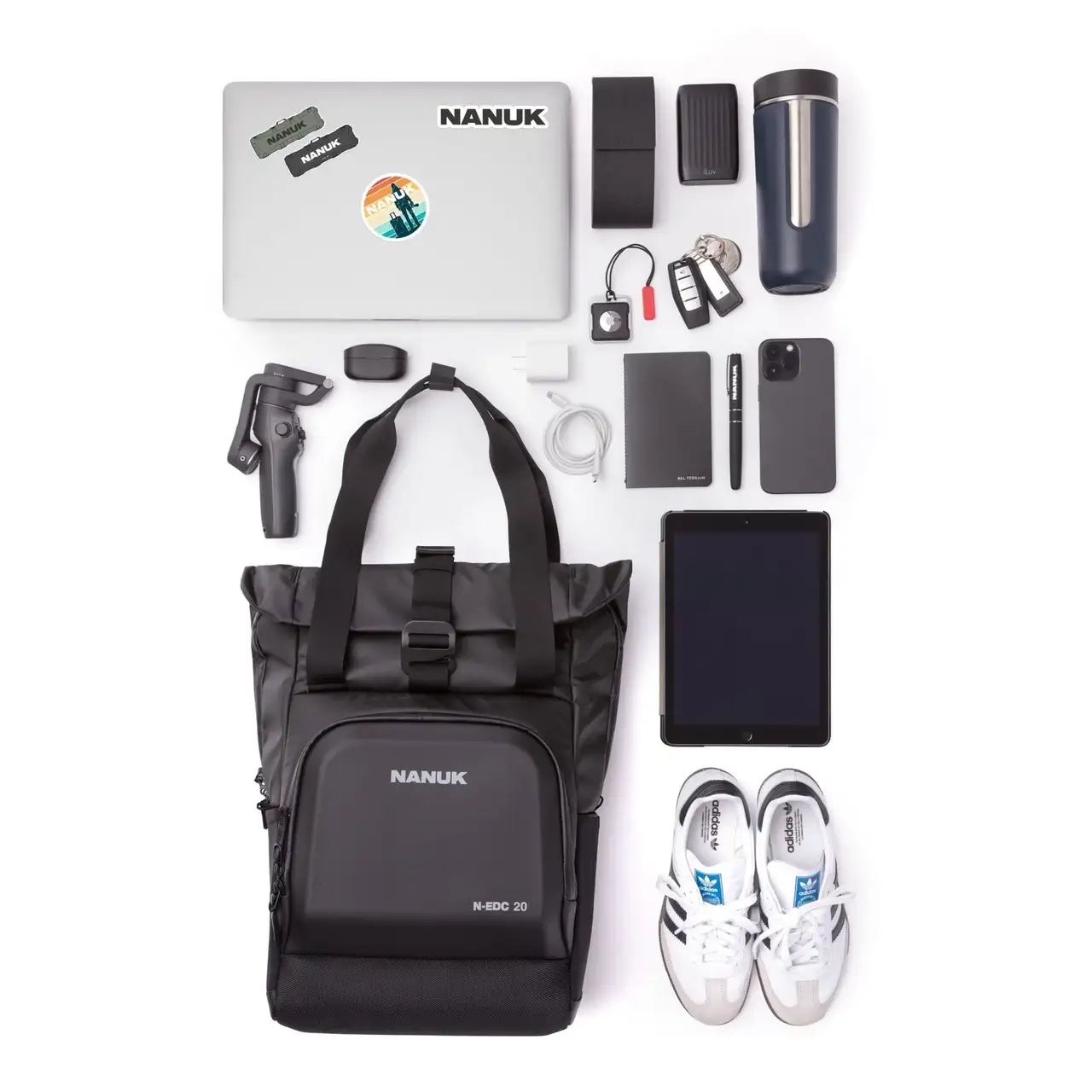 Collection of travel items including a laptop, backpack, shoes, and electronic devices on a white background.