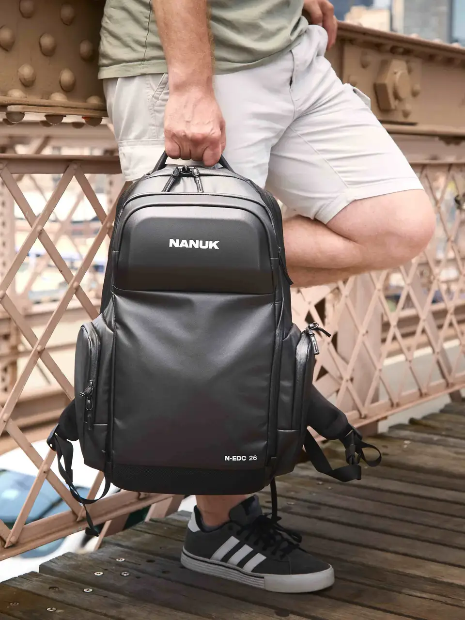 Person holding a JunZhiJia backpack on a bridge