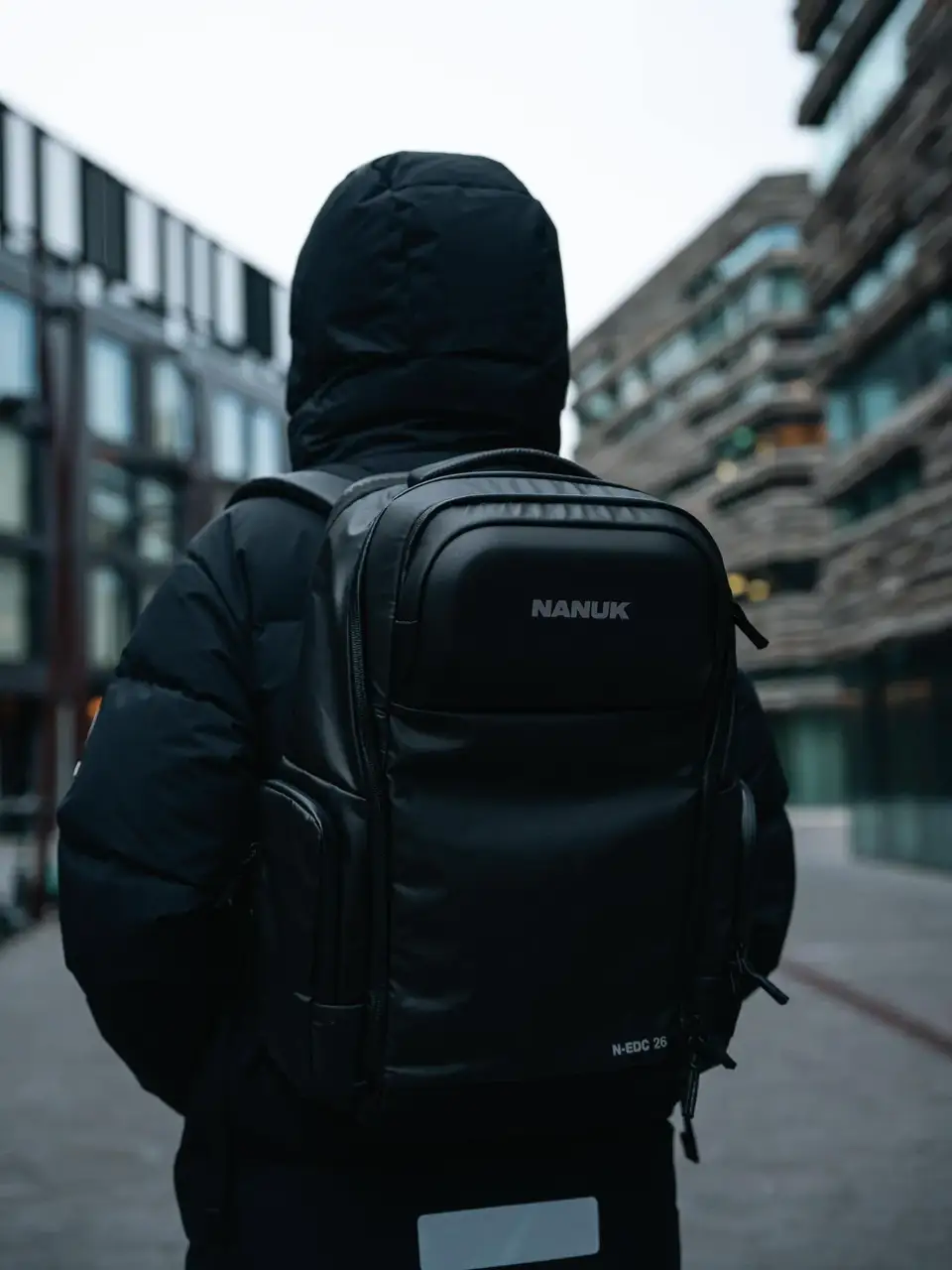 Person wearing a black JunZhiJia backpack in an urban setting