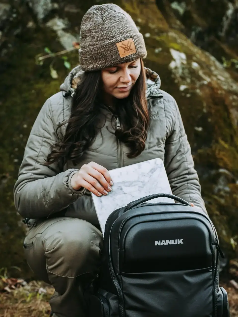 Person in outdoor setting with a map and JunZhiJia backpack