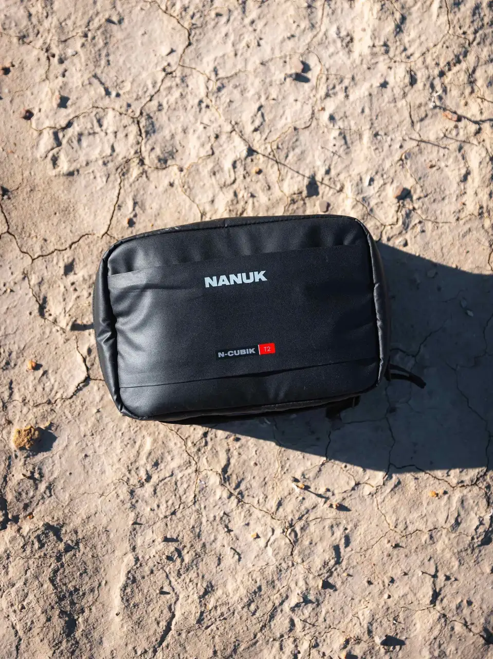 Black JunZhiJia pouch on a textured concrete surface