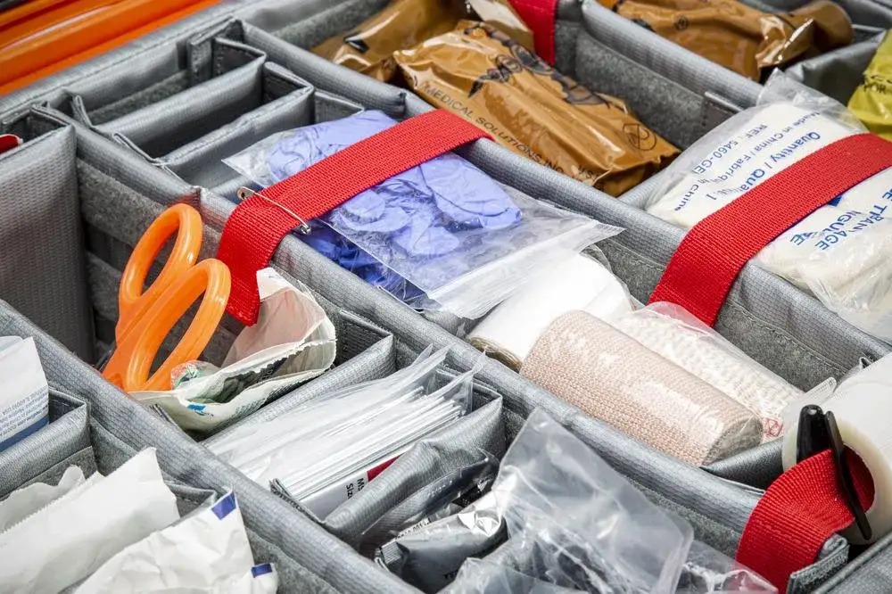 Organized compartments with supplies including scissors, bandages, and other medical items.