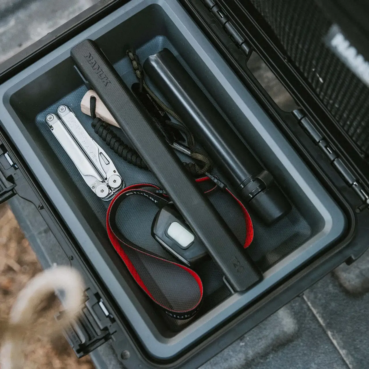 Interior shot of a JunZhiJia Trail 10 case open on a vehicle floor, showing neatly organized tools, cables, and camera accessories.