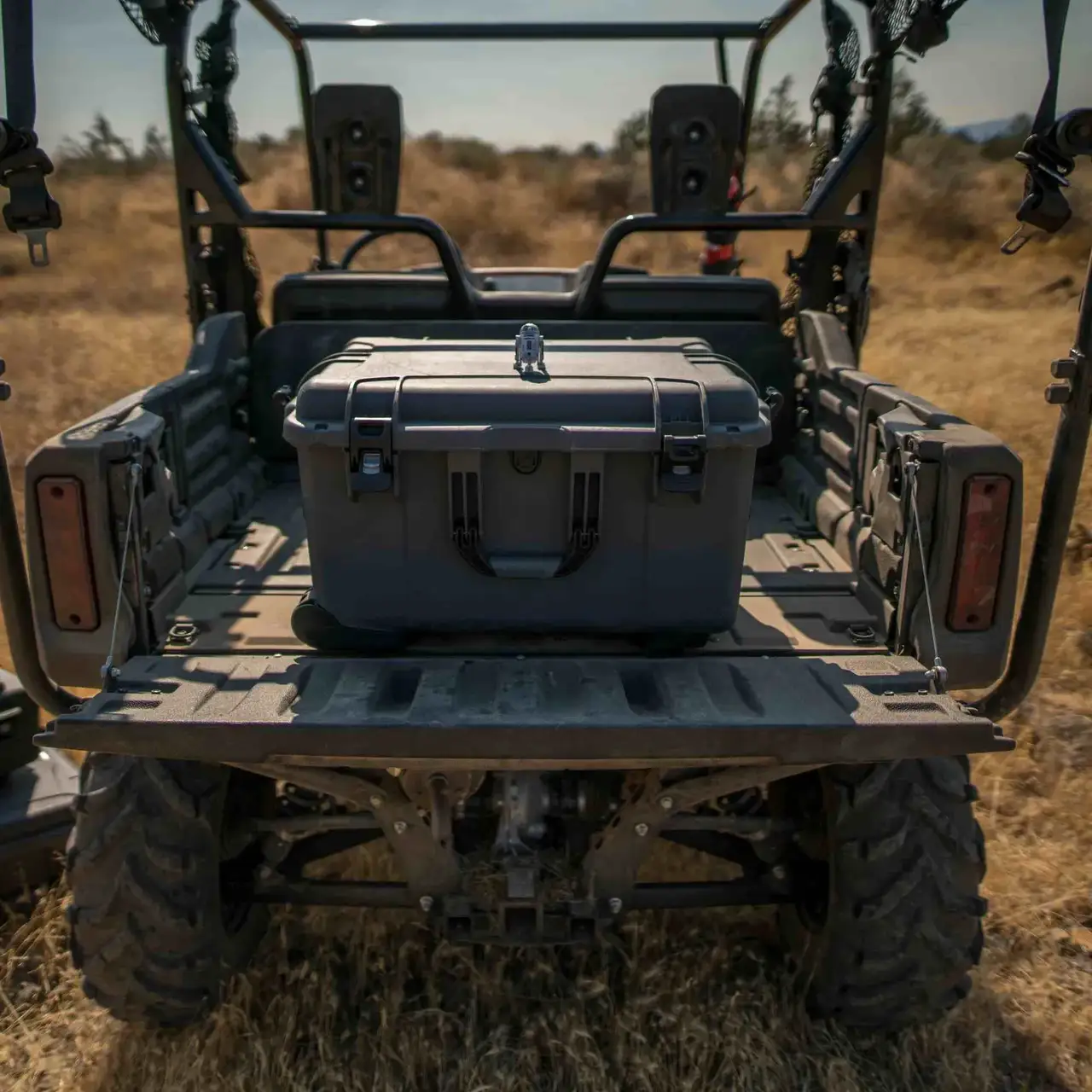 Gray JunZhiJia storage case on the back of a four-wheeler in a field