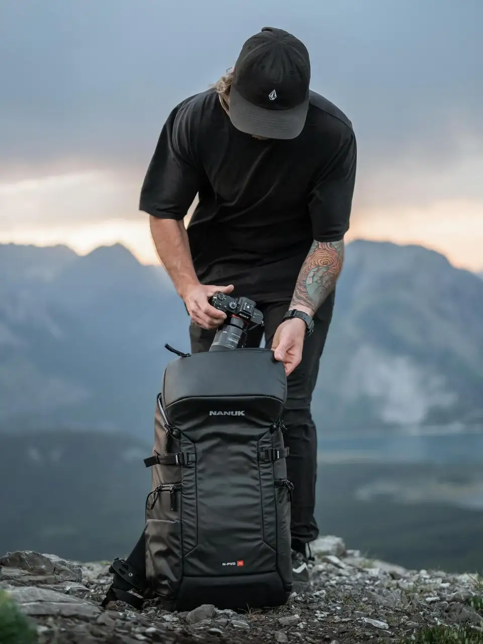 Person with a backpack on a mountain top with a scenic background