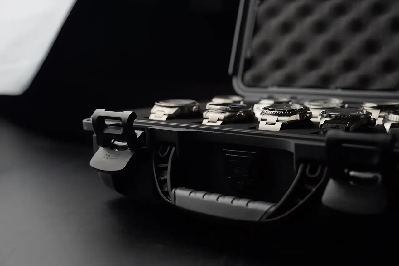 Black briefcase with watches on a dark surface