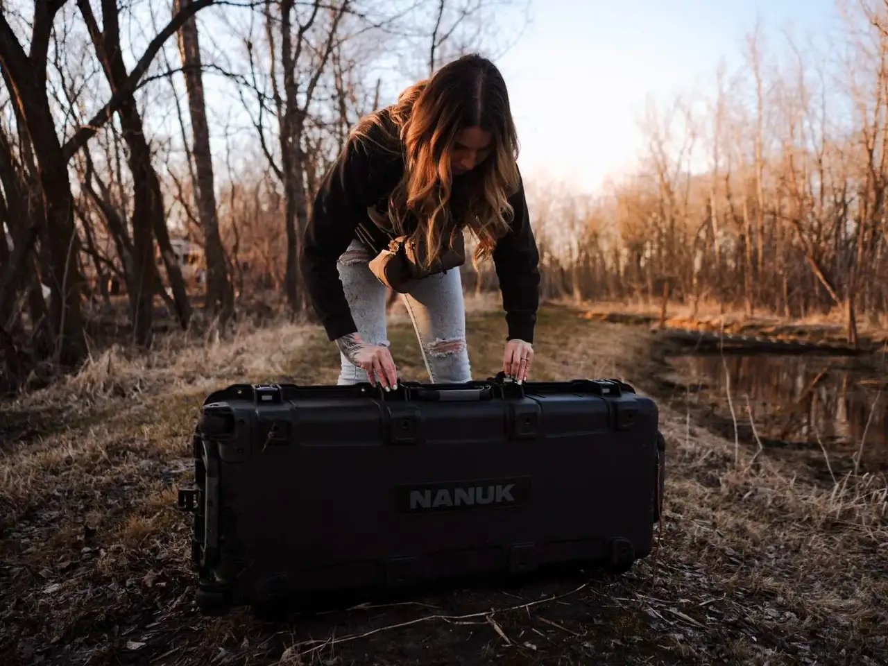 Person interacting with a JunZhiJia case in a forest setting