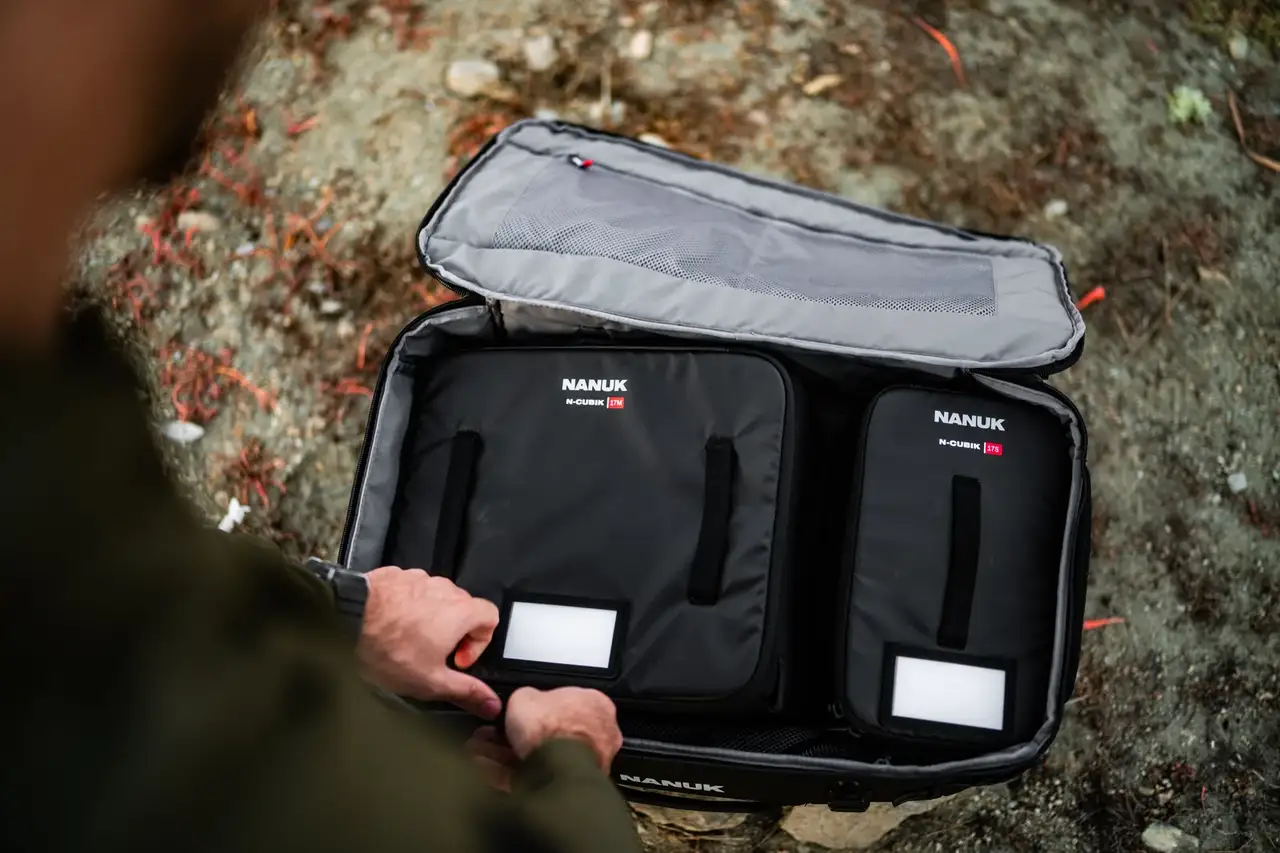 Person holding an open black JunZhiJia suitcase with visible branding.
