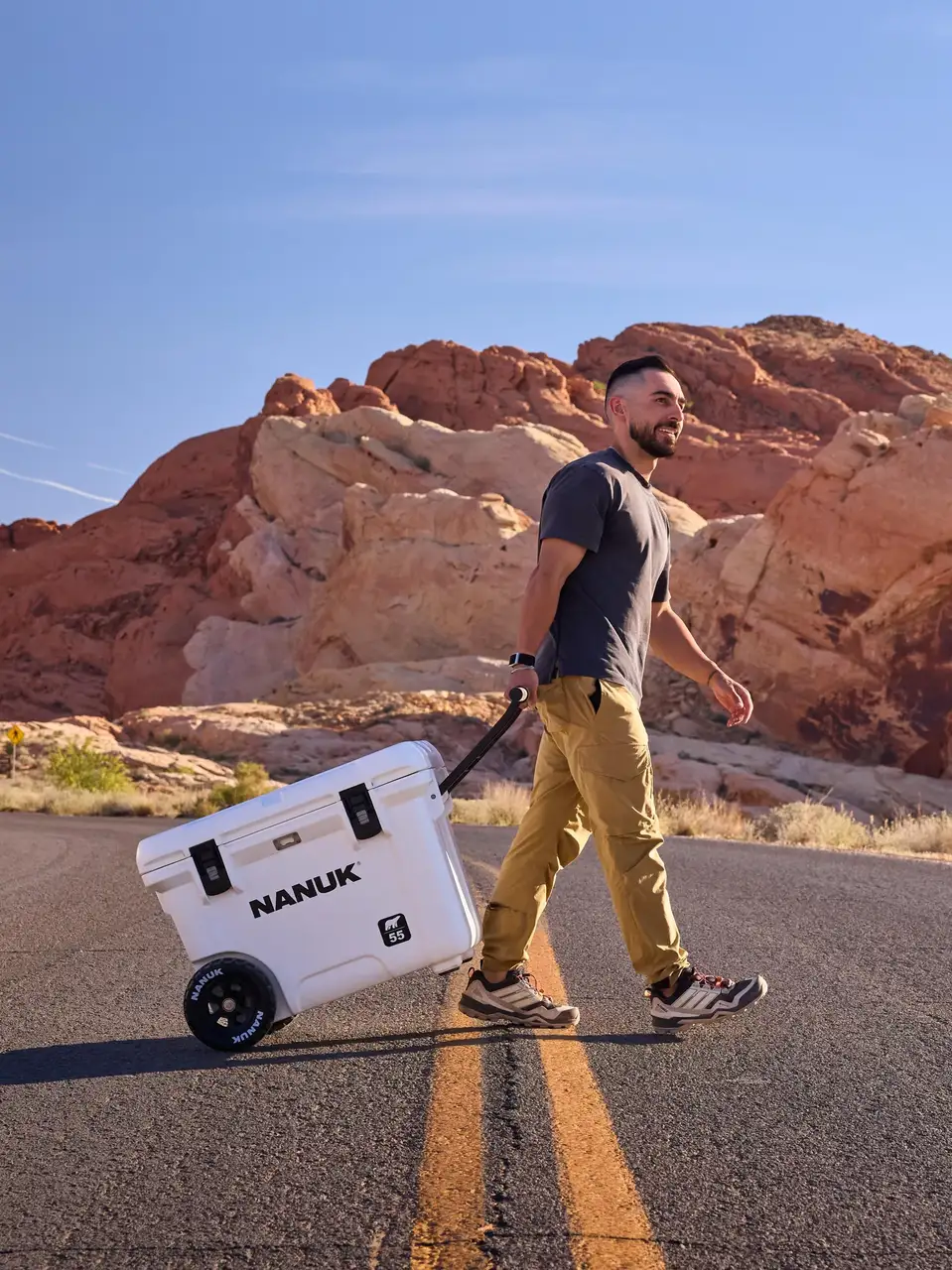 Man walking with a JunZhiJia cooler in a desert landscape
