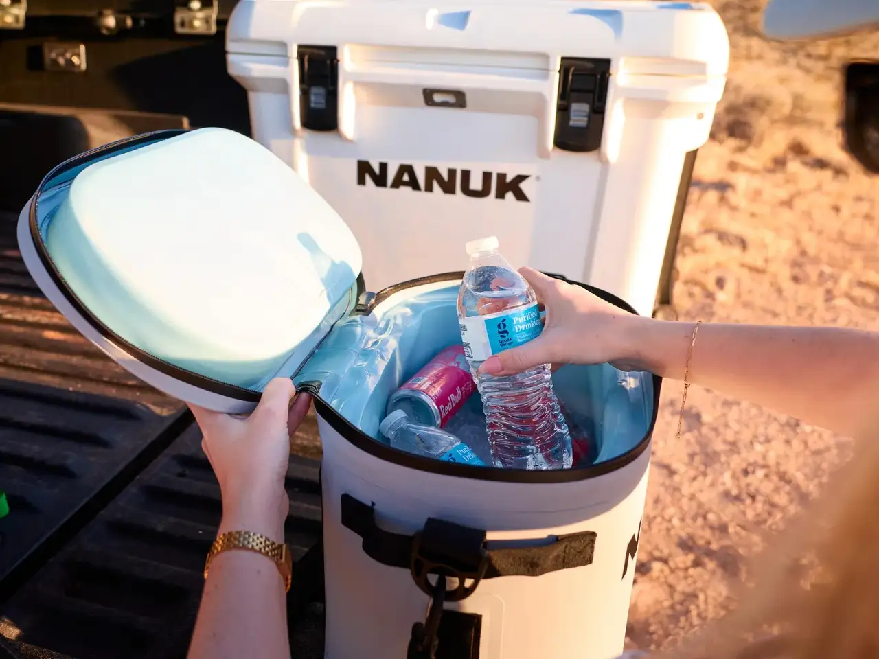 Person opening a JunZhiJia cooler with drinks inside, outdoors.