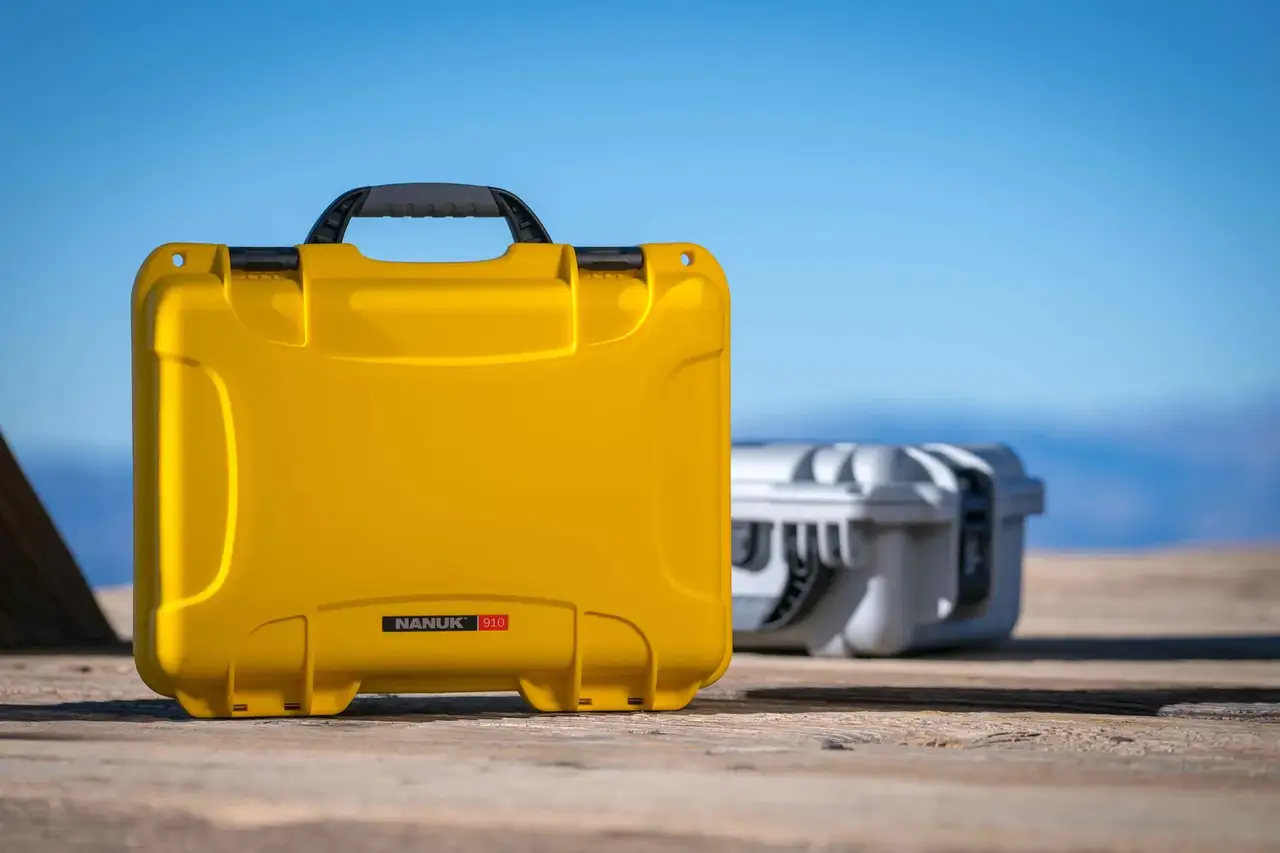 JunZhiJia 910 yellow hard case displayed on a wooden floor, showcasing its rugged exterior for ultimate protection.