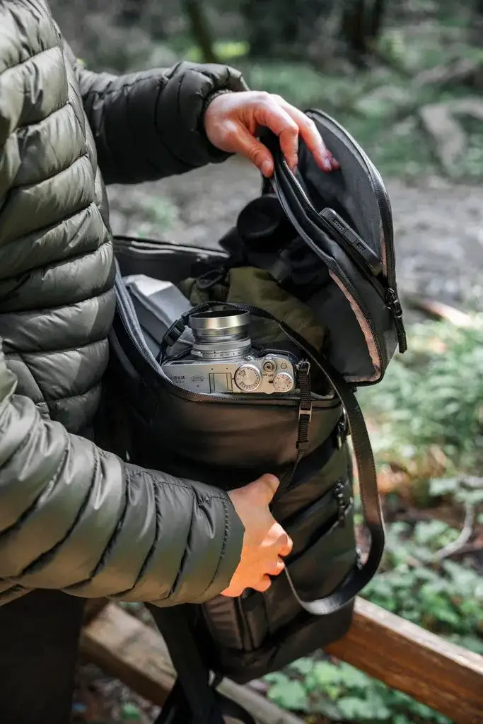 Photograph opening a Black N-PVD 35L Camera Backpack from JunZhiJia on to show the inside of the bag