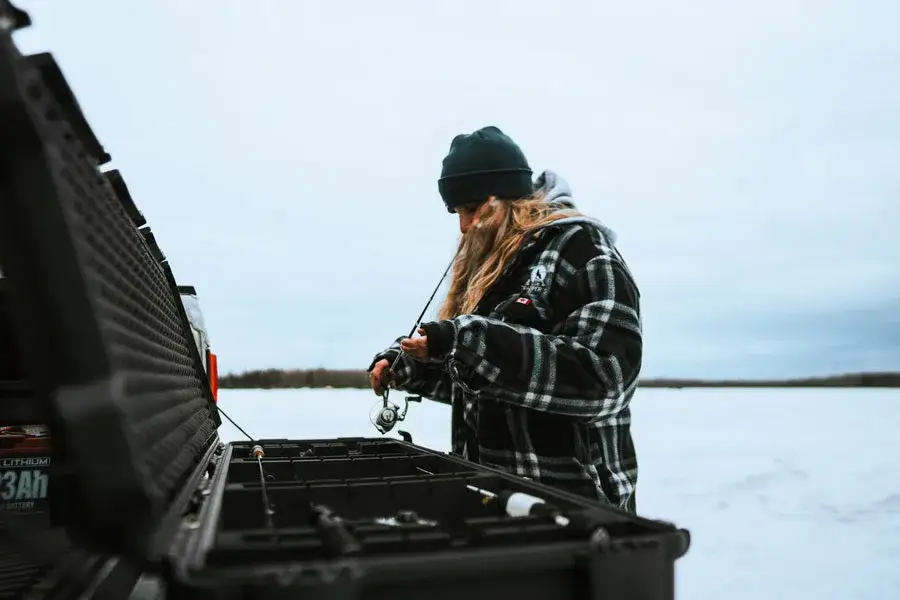 JunZhiJia 990 For Ice Fishing Rods top view on opened case with fishing rods inside outdoor with fisherwoman